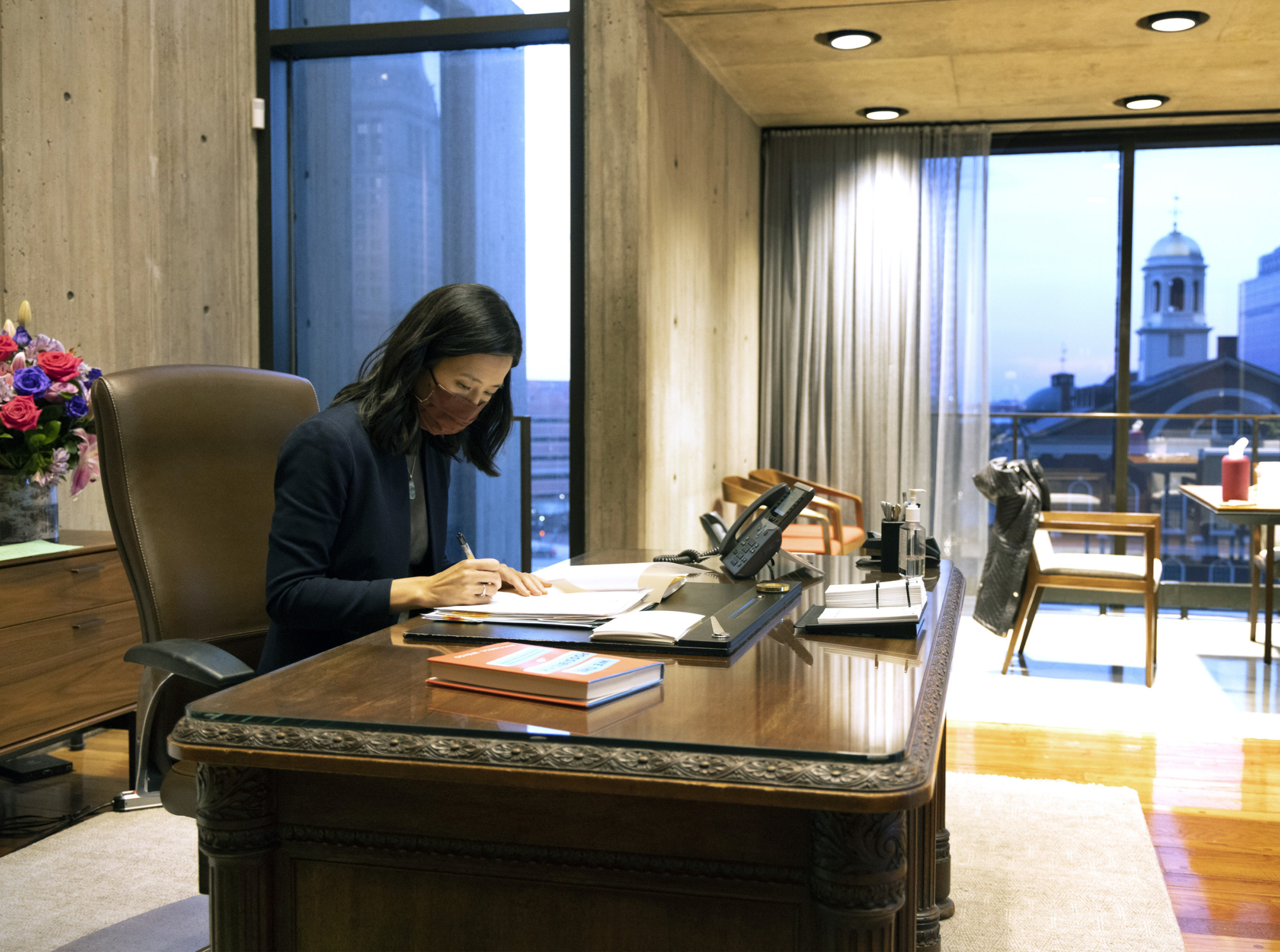 a person sitting at a desk reading paperwork