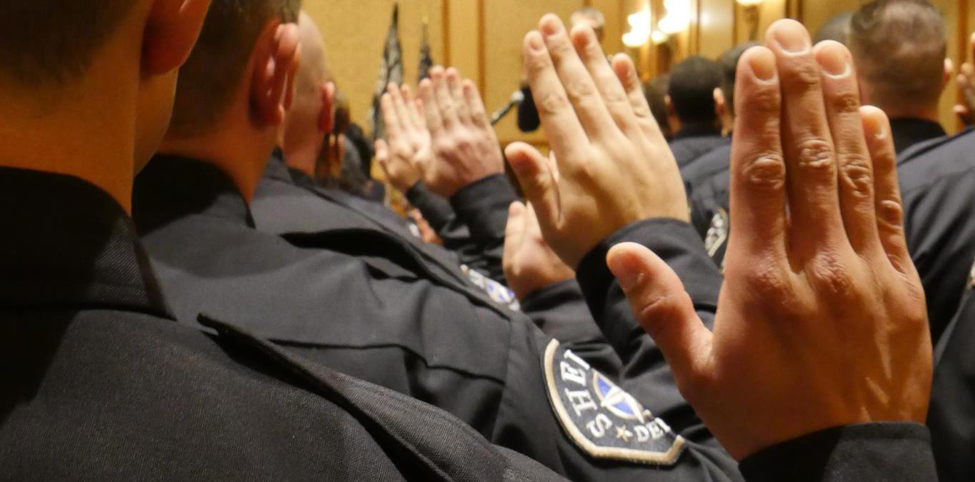 Denver Sheriffs standing in formation with hands raised for swearing in ceremony