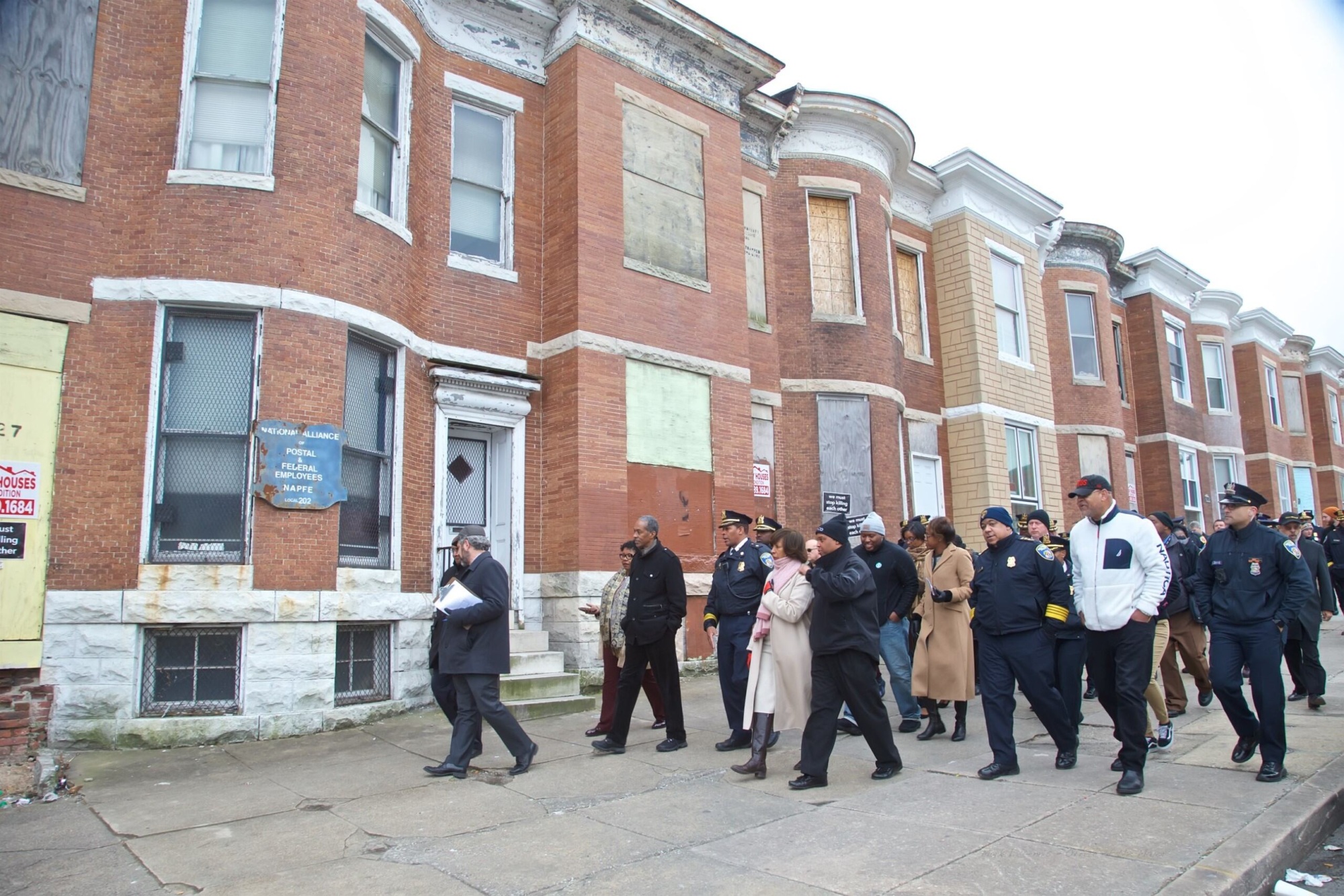 group of city leaders walking through the streets of Baltimore